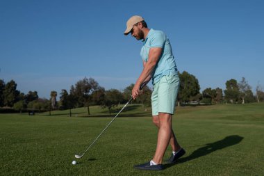 Golf oyuncusu güneşli bir günde golf oynuyor. Profesyonel golfçü golf sahasında vuruldu..