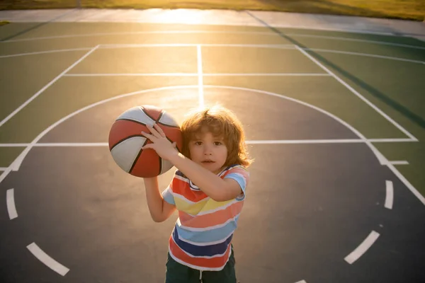 Kinderjongen bereidt zich voor op basketbal schieten. Beste sport voor kinderen. Actieve kinderen levensstijl. — Stockfoto