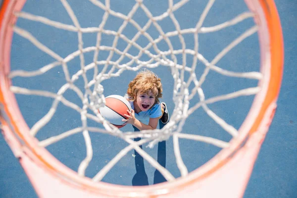 Ragazzo stupito che gioca a basket tenendo la palla con la faccia felice. — Foto Stock