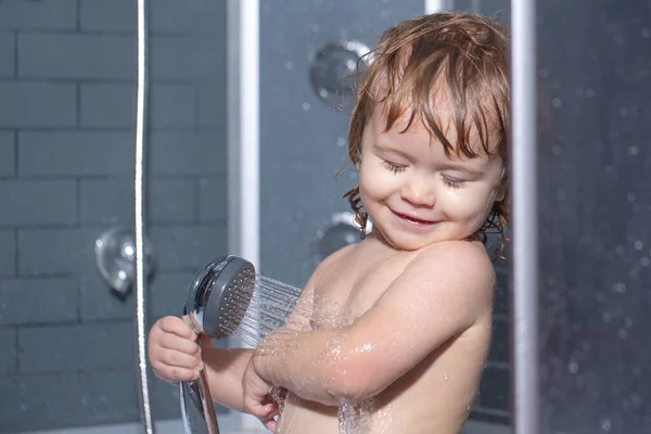 Kind heeft plezier in bad. Gelukkige baby die een bad neemt met schuimbelletjes. Babywassen en baden. Kinderopvang en hygiëne. — Stockfoto
