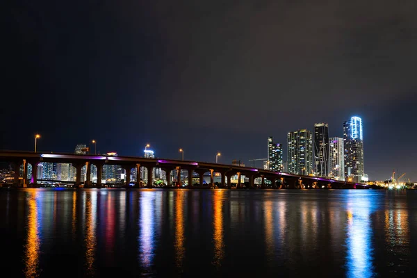 Noche en Miami, ciudad de Florida. Miami Florida, panorama al atardecer con coloridos edificios comerciales y residenciales iluminados y puente en la bahía de Biscayne. — Foto de Stock