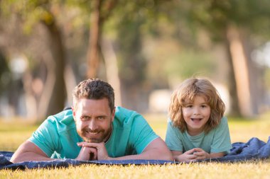 Mutlu baba ve oğul güneşli bir parkta tatilin tadını çıkarıyorlar..