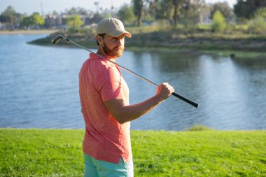 Golfçü akşam golf sahasında golf oynuyor. Güneşin altında golf oynayan bir adam..