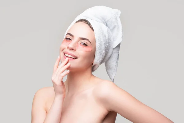 Närbild porträtt av sensuell tjej med handduk på huvudet och ögonlappar. Ögon mask kosmetiska fläckar kvinna ansikte närbild. — Stockfoto