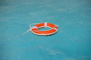 Yüzmek yok. Su kurtarma ekipmanları. Kurtarma halkası temiz havuz suyunda yüzüyor. Yaz.