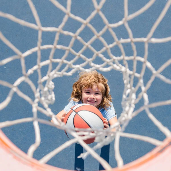 Horní pohled na roztomilé chlapeček hraje basketbal. Aktivní děti těší venkovní hru s basketbalem. — Stock fotografie