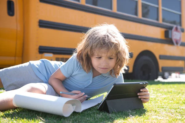 Schüler schreiben Hausaufgaben mit Laptop im Freien in der Nähe des Schulbusses. Fernstudium Online-Bildungskonzept. — Stockfoto