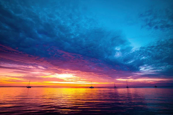 Hermoso amanecer tropical en la playa. Salida del sol sobre el mar y hermoso paisaje nublado. — Foto de Stock