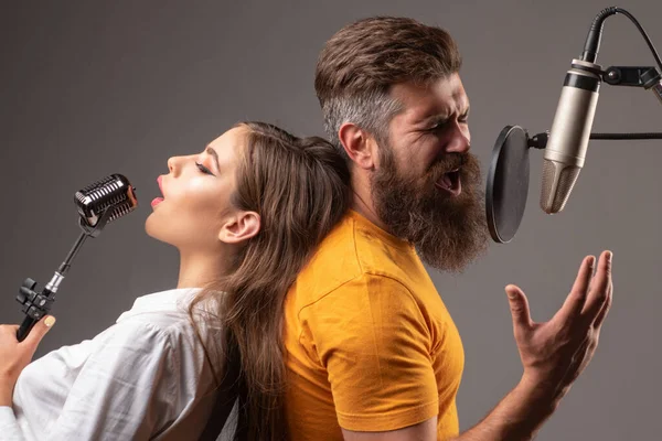 Een koppel dat zingt. Zanger vrienden zingen rock. Geluidsproducer opname nummer in een muziekstudio. Opgewonden Karaoke. — Stockfoto