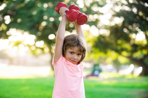 Çocuklar parkta spor yapıyor, spor yapıyor. Çocuklar sağlıklı bir yaşam tarzı. Güçlü kasları olan spor çocuğu.. — Stok fotoğraf
