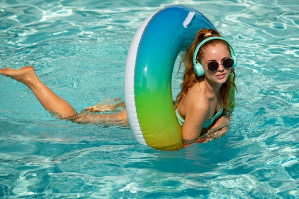 暑假。享受日光浴。穿着泳衣的女人在游泳池里戴着泳圈.联营度假胜地. — 图库照片