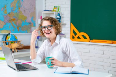 Okula dönelim. Sınıfta gülümseyen bayan öğretmen. Eğitim ve öğrenme kavramı.