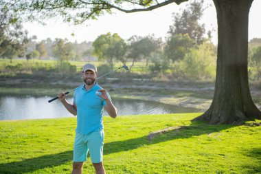 Golfçü adam güzel, güneşli yeşil golf sahasında golf oynuyor..