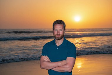 Sahildeki adam. Modaya uygun gömlek giyen muhteşem şık bir adam. Yaz gün batımı.