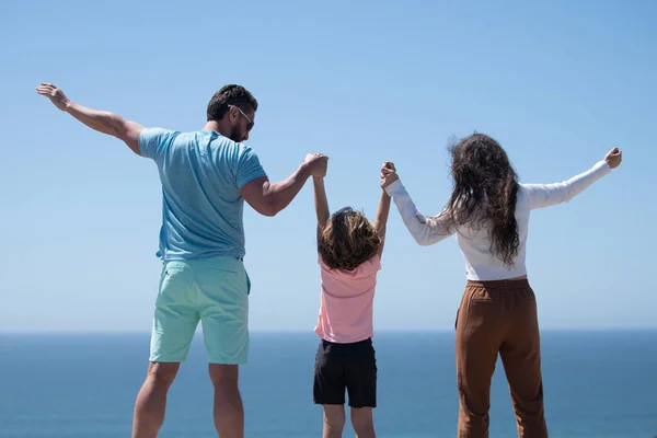 Счастливая семья на пляже. Люди веселятся на летних каникулах. Отец, мать и ребенок в голубом море. Беззаботная концепция семьи. — стоковое фото