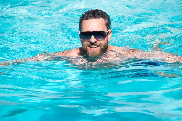 Pool resort. Handsome man at summer vacation. Man in sunglasses relaxing in swimming pool. — Stock Photo, Image