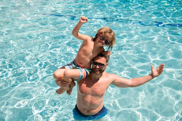 Vader en zoon in het zomerweekend. Kind met papa die in het zwembad speelt. Zwembadfeest. Sportactiviteiten. — Stockfoto