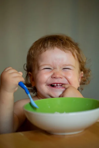 Bebê sorrindo comendo comida. Lançamento criança com colher. — Fotografia de Stock