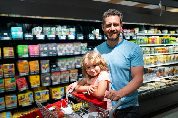 Πατέρας και γιος με καλάθι αγορών στο σούπερ μάρκετ επιλέγοντας τα τρόφιμα. — Φωτογραφία Αρχείου