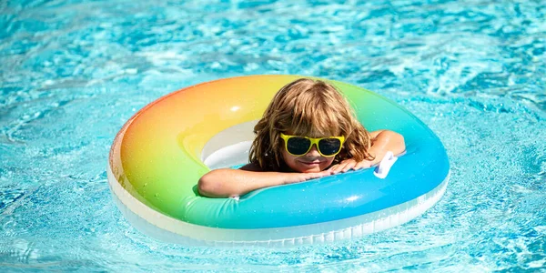 Letní prázdniny. Letní víkend. Kluk v bazénu. Dítě v aquaparku. Vtipný chlapec na nafukovací gumový kruh. — Stock fotografie