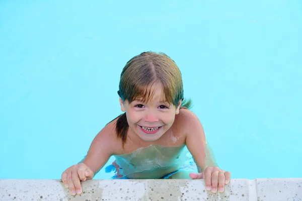 Criança na piscina de verão. Atividades de verão na piscina. A divertir-se no Aquapark. Miúdo a nadar na água. Criança feliz na piscina. — Fotografia de Stock