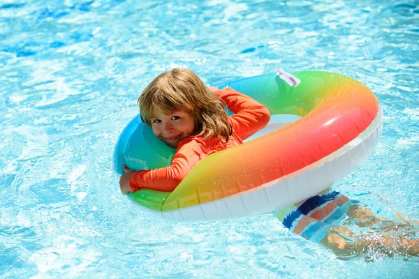 Kind in het zomerzwembad. Zomer kinderen vakantie. Zomer kindweekend. Een jongen in een zwembad. Jongen bij aquapark op opblaasbare rubberen cirkel. — Stockfoto