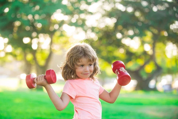 Un ragazzo che si allena nel parco. Sport per bambini. Stile di vita sano attivo. Bambino sportivo con manubrio. — Foto Stock