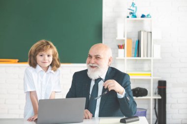İyi dersler. Okula dönelim. Eğitim ve öğrenim. Diz üstü bilgisayarı olan öğrenci ve öğretmen. Sınıfta okul çocuğuyla öğretmen. Öğrenmek için yardım.