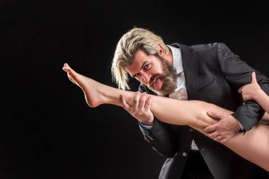 Kadın bacaklı, takım elbiseli yakışıklı bir adam. Ayak fetişisti. Lüks ve ataerkil düzen. Bacağını yala..