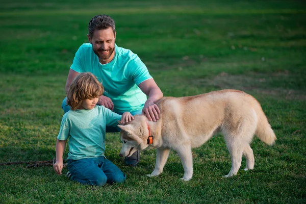 Pai e filho com cão animal de estimação ao ar livre. — Fotografia de Stock