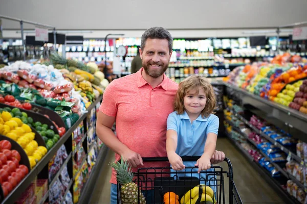 Padre e figlio comprano verdure fresche al supermercato. Famiglia in negozio. — Foto Stock