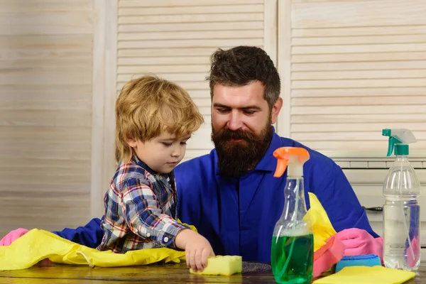 Man och barn dammar. Pappa och son städar vardagsrummet tillsammans. — Stockfoto