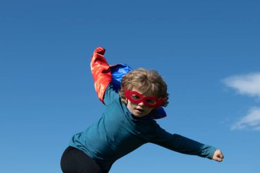 Süper atlayış. Süper kahraman gibi giyinmiş heyecanlı çocuk. Süper kahraman konsepti.