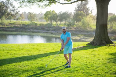 Golf sahasında golf oynayan bir adam..