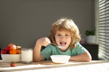 Çocuk evde sağlıklı yiyecekler yiyor. Bebek kaşıkla çorba içer.
