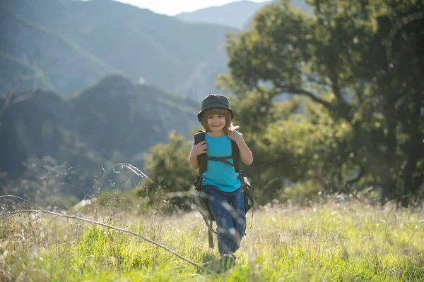 Sırt çantalı bir çocuk manzaralı dağlarda yürüyüş yapıyor. Çocuk yerel turist yerel bir yürüyüşe çıkıyor.. — Stok fotoğraf