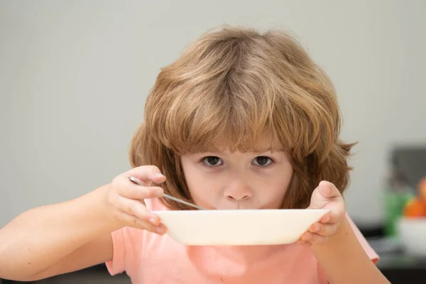 Kind eten. Kleine gezonde hongerige jongen die soep eet met lepel. Leuke nieuwsgierige hongerige grappige jongen. — Stockfoto