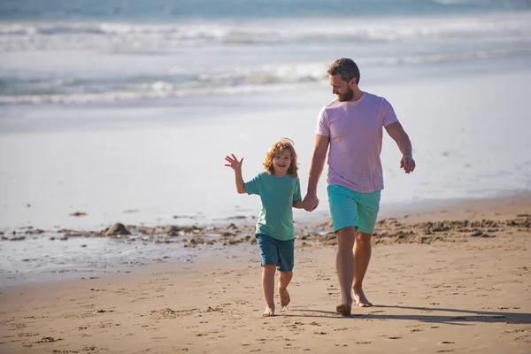 父と息子は海を歩いている。パパと子供が屋外で遊んで春の日を楽しむ. — ストック写真