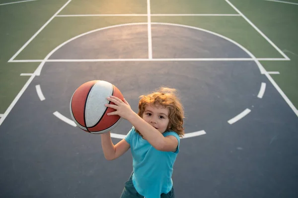 Το παιδί παίζει μπάσκετ με την μπάλα του μπάσκετ. Ενεργός τρόπος ζωής παιδιών. — Φωτογραφία Αρχείου