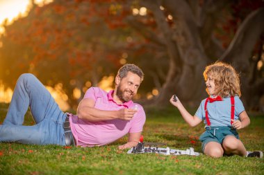 Baba oğluyla satranç oynar. Aile oyunu dışında. Akıllı çocuk, akıllı çocuklar..