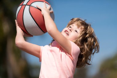 Parkta basketbol oynayan mutlu küçük çocuk. Çocuklar için spor.