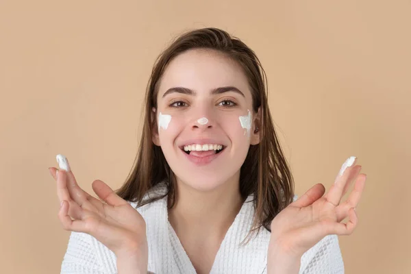 Beauty portrait of beautiful female model applying face cream. Woman with beauty face, natural skin, facial skin portrait. — Stock Photo, Image