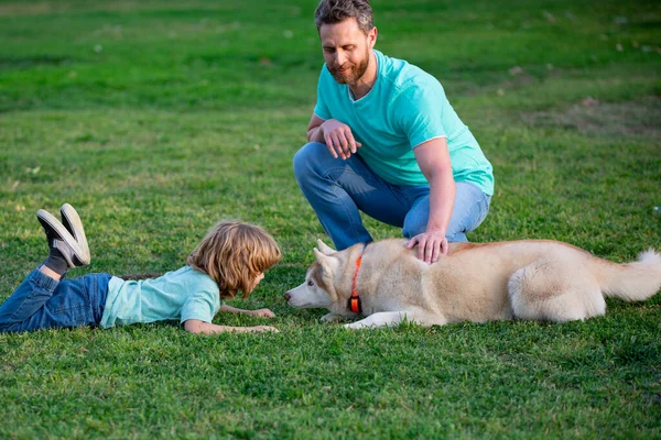 Dítě s miláčkem. Otec a syn se psem tráví čas venku. — Stock fotografie