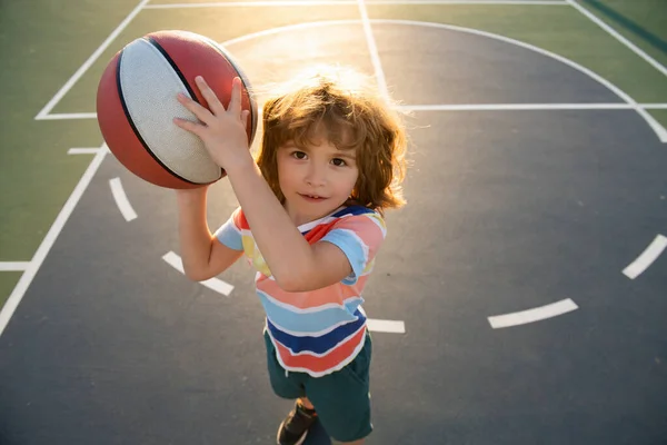 Chłopiec przygotowujący się do strzelaniny. Aktywny tryb życia. Szkoła koszykówki dla dzieci. — Zdjęcie stockowe