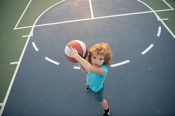 Malý chlapec hraje basketbal s košíkem. — Stock fotografie