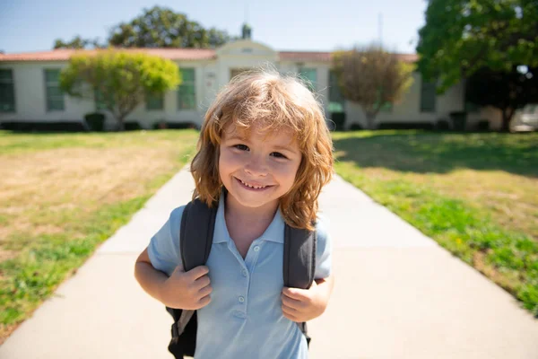 Grappig vrolijk schooljongen gezicht. Terug naar school. Schattig kind met rugzak lopen en naar school gaan. — Stockfoto