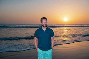 Gün batımında sahilde bir adam. Yaz tatili.