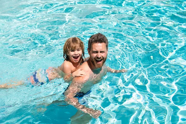 Papa en zoon zwemlessen. Zwembadfeest. Familie zomer weekeng. Vaderdag. — Stockfoto