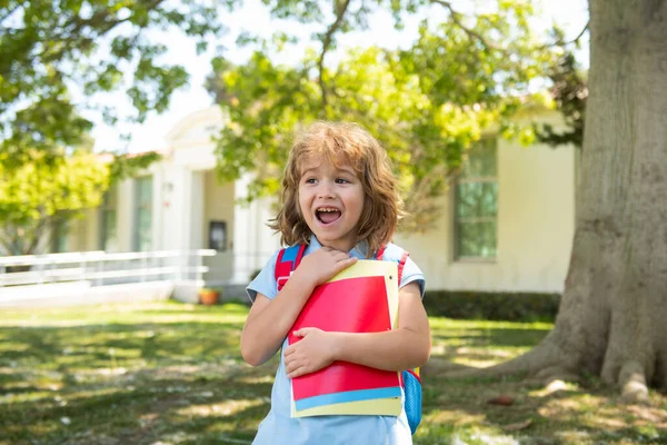 Je retourne à l'école. Enfant avec des sacs à dos debout dans le parc près de l'école. Elèves avec livres et sacs à dos à l'extérieur. — Photo