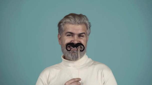 Concept de photomaton. Des accessoires de fête. L'homme qui s'amuse avec une fausse moustache. Des fous. Flirtant. — Video